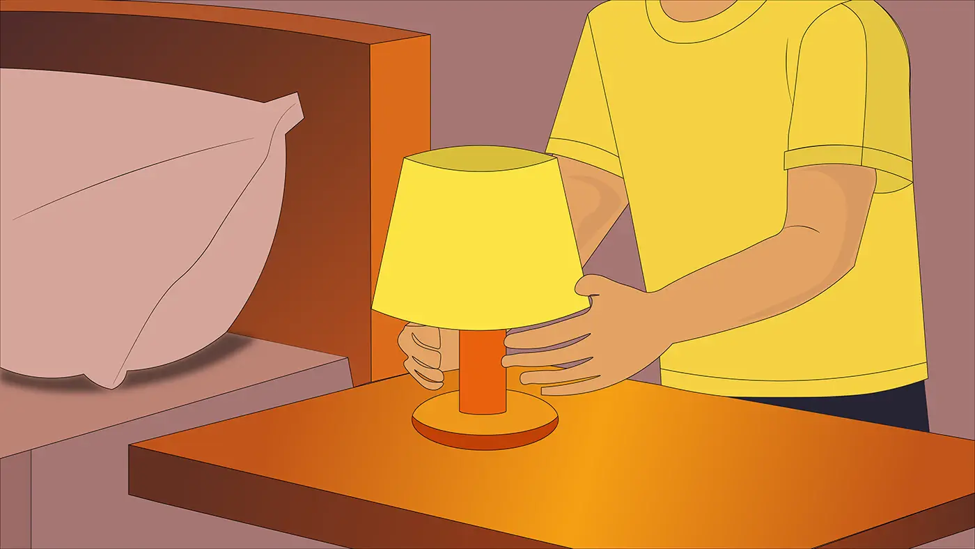 Hands switching on a warm bedside lamp